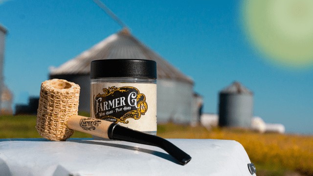 Farmer G jar on a farm truck, corncob pipe prop, grain silos in the background